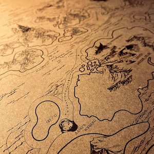 May include: A detailed map with black line art on a tan background. The map features geographical details, including landmasses, coastlines, and the text "Aang's Iceberg" and "Village". The map has a vintage, hand-drawn aesthetic.