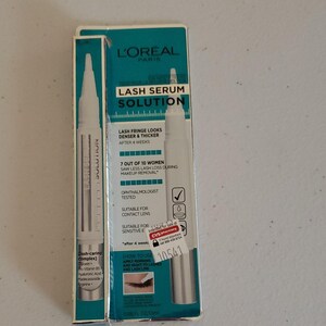 Può includere: L'Oréal Paris Lash Serum Solution in una scatola bianca e verde acqua. La scatola e l'applicatore del siero sono bianchi. Il testo sulla scatola recita "Lash Serum Solution" e "Lash fringe looks denser & thicker after 4 weeks."