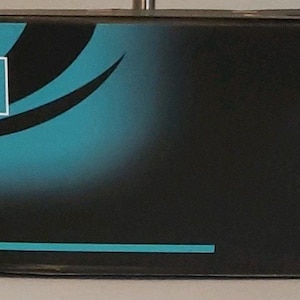 May include: A black box with the word "Hairdresser" in a white rectangle, with the word "Professional" below it. The box has a teal and black gradient design and a photo of a woman with long brown hair.