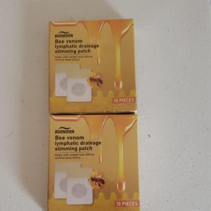 May include: Two boxes of BOOMOON bee venom lymphatic drainage slimming patches. The boxes are yellow with a honey-like design and feature a bee illustration. Each box contains 10 pieces and claims to help with weight loss and remove body toxins.