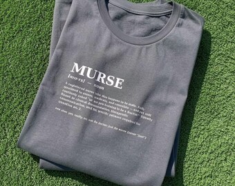 May include: A charcoal grey crew neck t-shirt featuring white printed text that defines the word MURSE as a noun, including a phonetic pronunciation and a humorous dictionary-style description of a male nurse's professional role.