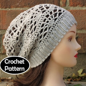 May include: A crocheted beanie hat in a light gray color with a lacy pattern. The hat is being worn by a mannequin with long brown hair. The text "Crochet Pattern" is visible in the lower left corner of the image.