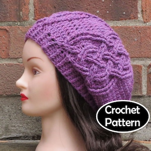 May include: Purple crochet beanie hat with a cable stitch pattern. The hat is on a mannequin head with long brown hair. The text "Crochet Pattern" is on a black oval sticker.