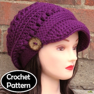 May include: Purple crochet hat with a button and a brim. Crochet Pattern.