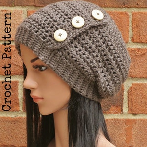 May include: A brown crocheted beanie with three large white buttons. The beanie is slouchy and has a fold-over brim.