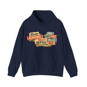 May include: Navy blue hoodie with a front graphic. The graphic features the words "Keep Going," "You Got This," "Never Settle," and "Dream Big" in a vintage style. The phrase "Old School Inspiration" is also included.