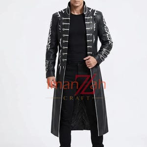 May include: A black long coat featuring white branch-like patterns on the sleeves, a high collar, and two vertical rows of silver buttons. The coat is worn over a black shirt and black trousers. The text ImanZah CRAFT is visible in the center.
