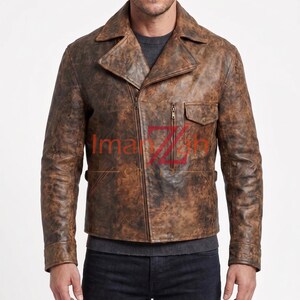 May include: A distressed brown leather jacket featuring a wide notched collar, an asymmetrical front zip closure, a small chest pocket with a flap, and long sleeves with cuffs. The text ImanZah Craft is printed in red and brown across the chest.