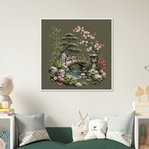 Könnte beinhalten: Ein gerahmter Druck einer japanischen Gartenszene. Das Kunstwerk zeigt eine kleine Bogenbrücke über einem Bach, umgeben von Felsen, Bambus und blühenden Bäumen. Eine Steinlaterne ist ebenfalls zu sehen. Die Farbpalette umfasst Grün-, Rosa- und Brauntöne.