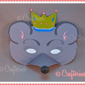 May include: A grey mouse mask with a pink nose, white eyes, and black eyelashes. The mask has a gold crown with pink and blue accents on top. The crown has the text "Crafterina" on it.