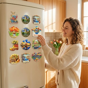 May include: A selection of vibrant souvenir magnets showcasing Dutch imagery, such as windmills, tulips, and cityscapes, attached to a cream-coloured refrigerator. The magnets feature text including "Rotterdam" and "Amsterdam".