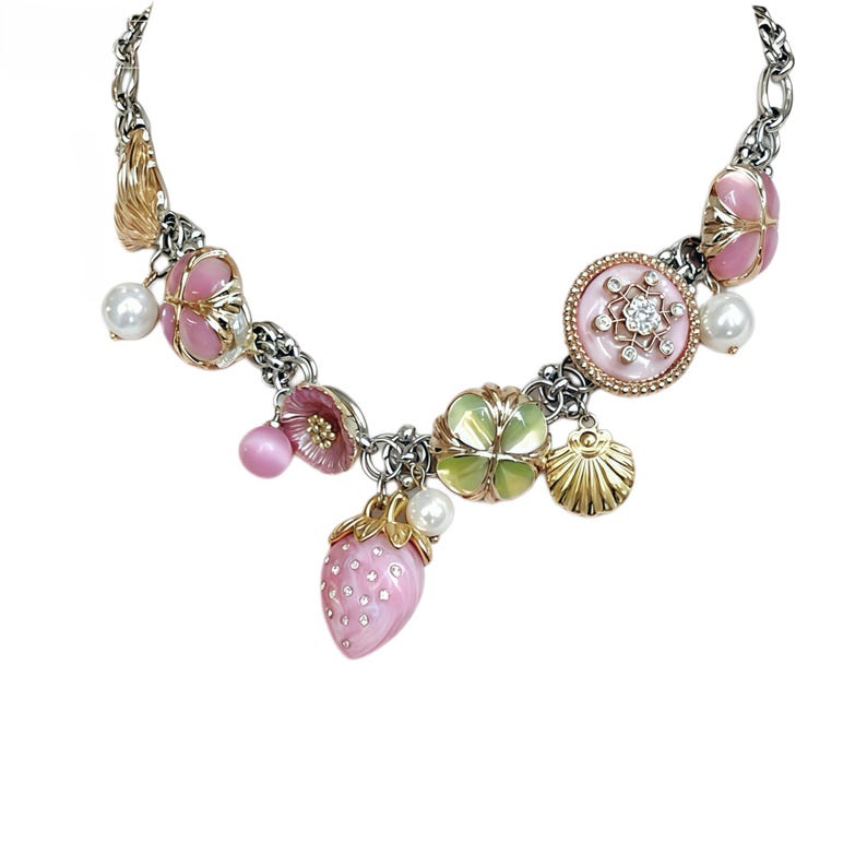 May include: A silver-tone chain necklace with various charms. The charms include pink flowers, a strawberry, a seashell, and a circular pendant with a crystal. The necklace also features faux pearls and a gold-tone leaf charm. The necklace is on a white background.