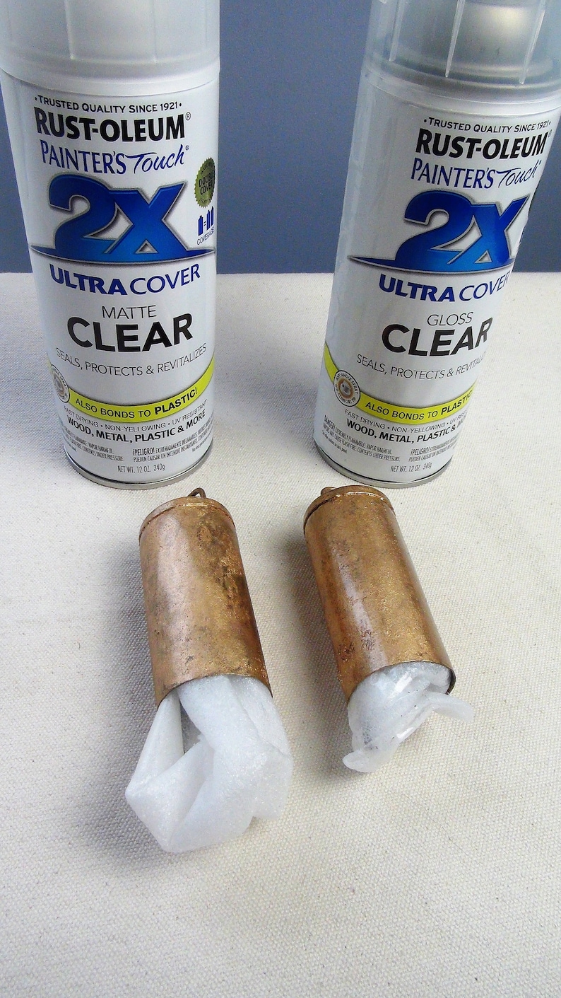 May include: Two cans of Rust-Oleum Painter's Touch 2X Ultra Cover clear spray paint. One can is matte finish and the other is gloss finish. Both cans are 12 oz. and are on a white surface.