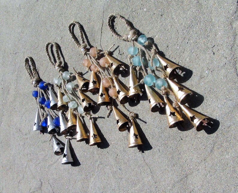 May include: Four sets of wind chimes with different colored glass beads and gold bells. Each set has a different color of beads: blue, green, pink, and white.