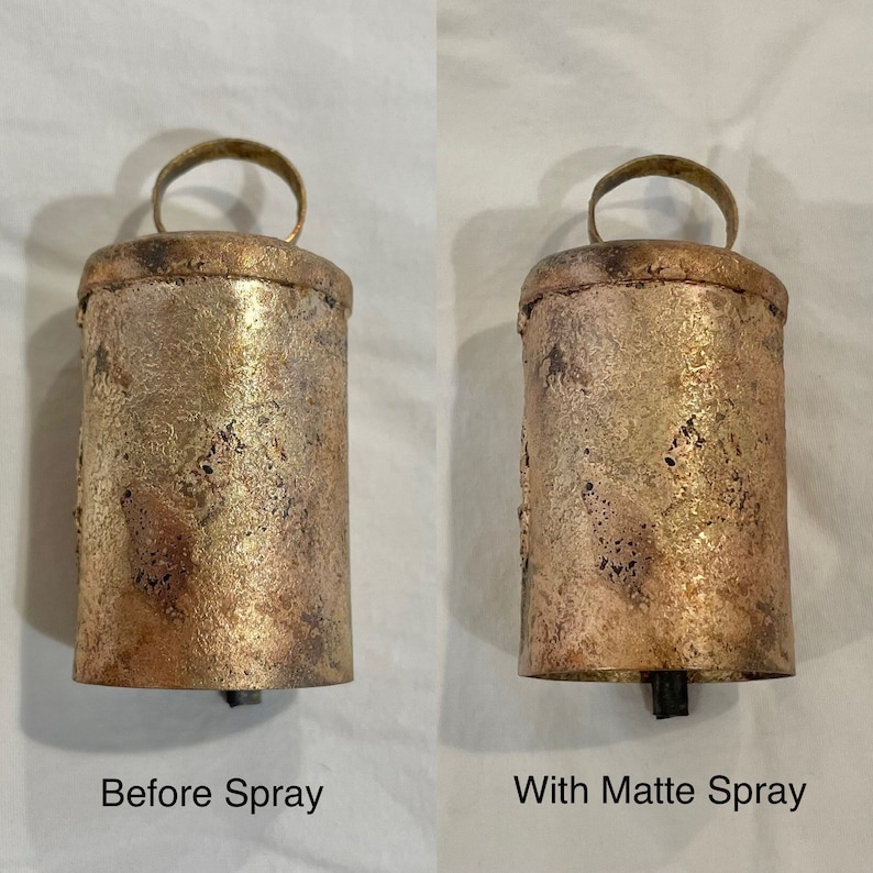 May include: Two antique-style metal bells, one with a shiny finish and the other with a matte finish. The bells are both the same size and shape, with a rounded top and a handle.