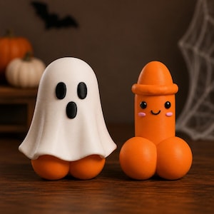 Peut inclure: Deux petites figurines. L'une est un fantôme blanc avec des yeux et une bouche ovales noirs, recouvrant une base orange. L'autre est une figurine orange de forme phallique avec un sommet arrondi, des yeux noirs, un sourire et des joues roses.