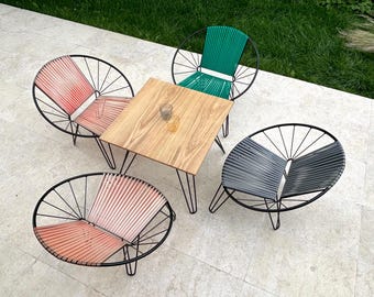 Sillas estilo espagueti con una pequeña mesa cuadrada