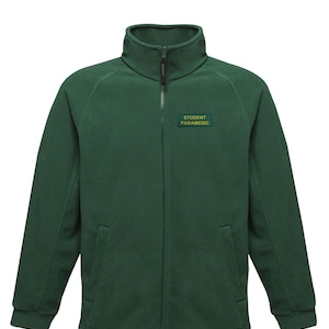 May include: A dark green fleece jacket with a full-length zipper and a high collar. The jacket has a small rectangular patch on the chest that reads "STUDENT PARAMEDIC" in green lettering. The jacket has two front pockets and long sleeves.