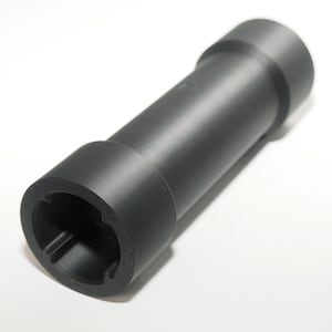 May include: A cylindrical, black object with a hollow interior and a textured surface. The object has a stepped design with a wider diameter at both ends and a narrower central section. The ends have a unique, notched pattern.