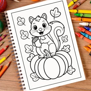May include: A spiral-bound coloring book page featuring a black and white line art illustration of a squirrel holding an acorn while sitting on top of a large pumpkin, surrounded by several scattered autumn leaves on a wooden surface.