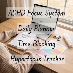 Op de afbeelding: Een laptop, notitieboek en gedrukte planner liggen op een houten bureau. Op het notitieboek staat "ADHD Focus System". De gedrukte planner is gelabeld met "Daily Planner" en "Hyperfocus Tracker".