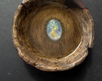Hermoso camafeo iridiscente que realza un cuenco de madera rústica.
