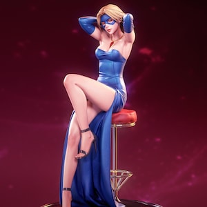 Op de afbeelding: Een blond beeldje in een blauwe strapless jurk met bijpassende blauwe operahandschoenen en een blauw oogmasker. Het figuur zit op een barkruk met een rode zitting en een verchroomde voet. De voet bevat de tekst PATREON | KuruFigure.