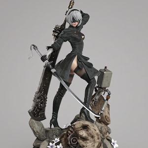 May include: A detailed figurine of a character in a black dress, high-heeled boots, and a blindfold, holding a large sword and a smaller blade. The figure stands on a rocky base with a mechanical companion and decorative flowers. The figurine is approximately 12 inches tall.
