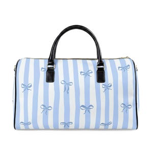 Puede incluir: Una bolsa de viaje a rayas azules y blancas con asa negra y detalles negros. La bolsa presenta un patrón de lazos azules. La bolsa tiene cierre de cremallera y está diseñada para viajar.