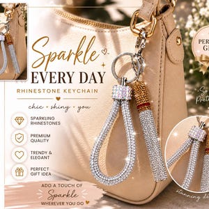 May include: A rhinestone keychain featuring a silver-toned loop and a cylindrical charm, both encrusted with clear and amber-colored crystals. The keychain is attached to a metal ring and clip, displayed against a beige handbag with text overlays.