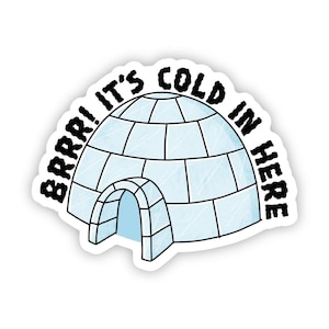 May include: A die-cut sticker featuring a light blue and white illustration of an igloo with a rounded entrance. The text "BRRR! IT'S COLD IN HERE" is printed in bold, black, hand-drawn style lettering arching over the top of the igloo structure.