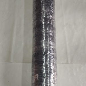 May include: A cylindrical roll of black mesh material tightly wrapped in clear plastic film. The mesh features a consistent grid pattern throughout its length, and the protective plastic covering creates a reflective, crinkled texture over the surface.