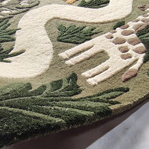 May include: A rectangular tufted rug featuring a jungle theme with a light green background. The design includes a tan lion, a white winding path, and a giraffe with brown spots. Dark green palm leaves and foliage are tufted throughout the rug.