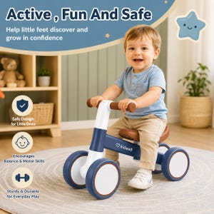 May include: A navy blue and white balance bike with brown handlebars and seat, featuring the Kidwell logo on the frame. The bike has four wheels and is designed for toddlers to develop balance and motor skills while playing indoors.