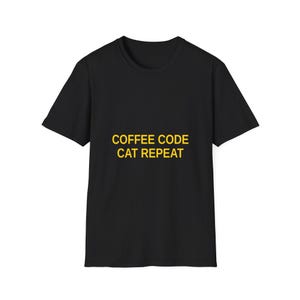 Può includere: T-shirt nero con la scritta gialla "COFFEE CODE CAT REPEAT". La maglietta ha maniche corte e girocollo. Il testo è centrato sulla parte anteriore della maglietta.