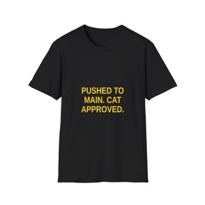 Könnte beinhalten: Schwarzes T-Shirt mit dem Text "PUSHED TO MAIN. CAT APPROVED." in gelben Blockbuchstaben. Das Shirt hat kurze Ärmel und einen Rundhalsausschnitt. Der Text ist mittig auf der Vorderseite des Shirts platziert.