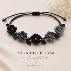 May include: A black macrame bracelet featuring crocheted flower accents in shades of black and gray, interspersed with small silver beads. The bracelet is adjustable and includes the text "Midnight Bloom Bracelet".