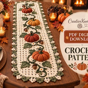 Peut inclure: Un chemin de table en crochet couleur crème orné d'un motif de vigne central avec quatre citrouilles en relief dans des tons rouge, orange et jaune, agrémenté de feuilles vertes, de petites fleurs blanches et de glands marron, avec le texte CreativeKnotWool PDF DIGITAL DOWNLOAD CROCHET PATTERN.