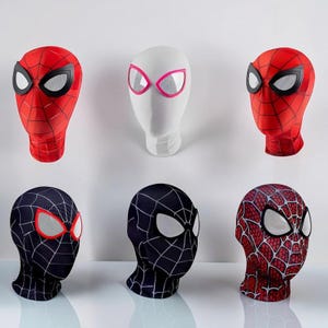 Könnte beinhalten: Sechs Superheldenmasken auf Schaufensterpuppenköpfen. Zwei sind rot mit schwarzem Netzmuster und weißen Netzaugen. Eine ist weiß mit pink umrandeten Augen. Zwei sind schwarz mit weißem Netzmuster und weißen Netzaugen. Eine ist rot mit schwarzem Muster.