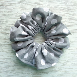 May include: Gray fabric scrunchie with white polka dots.