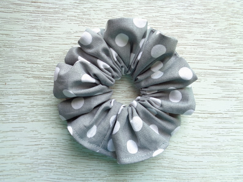 May include: Gray fabric scrunchie with white polka dots.
