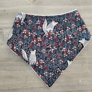 May include: A black bandana with a white fox and floral pattern. The bandana has a white border.
