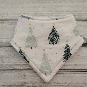 May include: A white bandana with a Christmas tree pattern. The trees are green and black with gold stars. The bandana has a white background with gold dots.