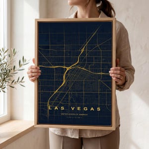 Può includere: Una mappa incorniciata di Las Vegas, Nevada, negli Stati Uniti. La mappa presenta una griglia stradale e autostrade color oro su uno sfondo blu scuro. Il nome della città è visualizzato in lettere dorate in basso, con il nome del paese sottostante.