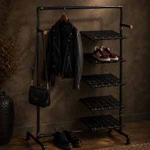 Pode incluir: Um cabideiro de tubos de metal preto com cinco prateleiras quadradas, uma barra de suspensão e detalhes na cor latão. O cabideiro sustenta uma jaqueta de couro preta em um cabide, uma bolsa preta, tênis bordô e sapatos pretos.