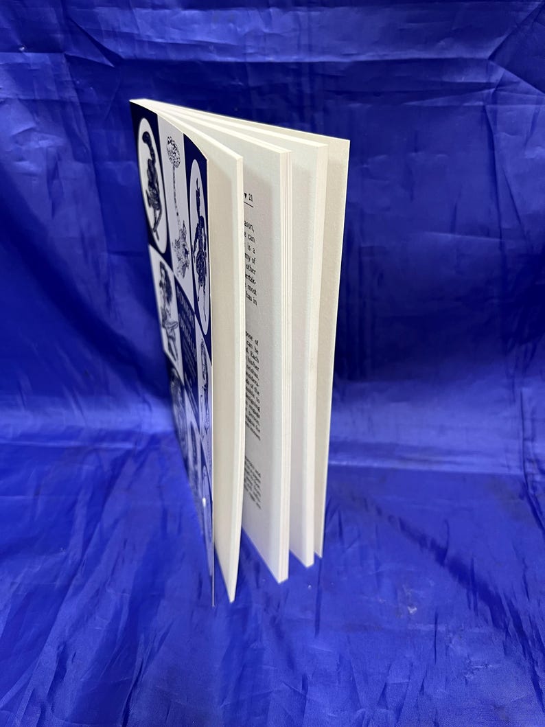 May include: A book with a white cover and pages, featuring black and white illustrations. The cover displays several images in a grid pattern. The book is open, revealing the text on the pages.