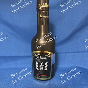 May include: A dark glass bottle of Siete Machos cologne with a black label featuring gold accents, white goat head illustrations, and text reading Siete Machos, Locion, and 110 ml 3.72 Fl. Oz. The bottle has a black cap with gold lettering.