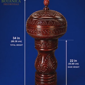 May include: A dark brown carved wooden vessel with a lid, featuring intricate floral and geometric patterns. The total height is 34 inches, and the base height is 22 inches. The text BOTANICA IREORISHAS is visible in the upper left corner.