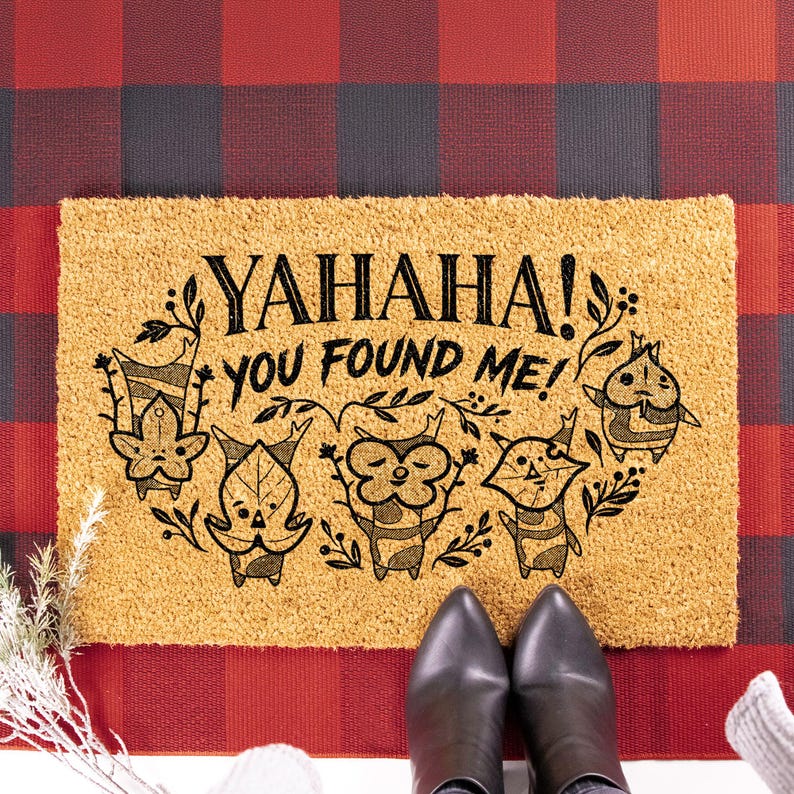 K&ouml;nnte beinhalten: Rechteckige Kokos-Fu&szlig;matte mit dem Text "YAHAHA! YOU FOUND ME!" und Illustrationen von Charakteren. Die Matte ist beige mit schwarzen Buchstaben und Illustrationen, vor einem rot-schwarz karierten Hintergrund.