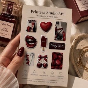 May include: Aesthetic sticker set featuring various red-themed designs, including lips, a heart, cherries, and macarons. The sticker sheet is labeled "Printera Studio Art" and includes text indicating the stickers are 3D, waterproof, fade-resistant, and durable.